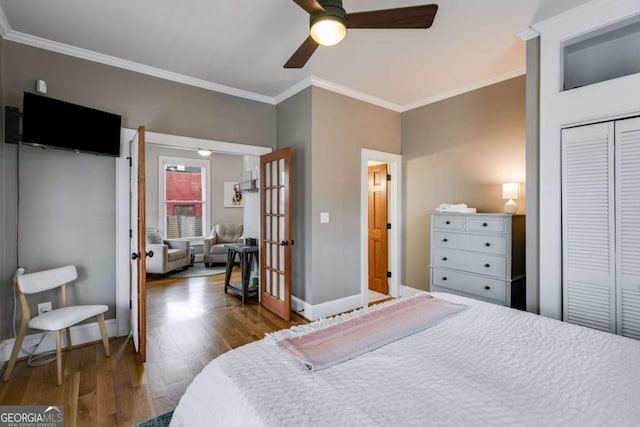 bedroom featuring wood-type flooring, ornamental molding, a closet, and ceiling fan