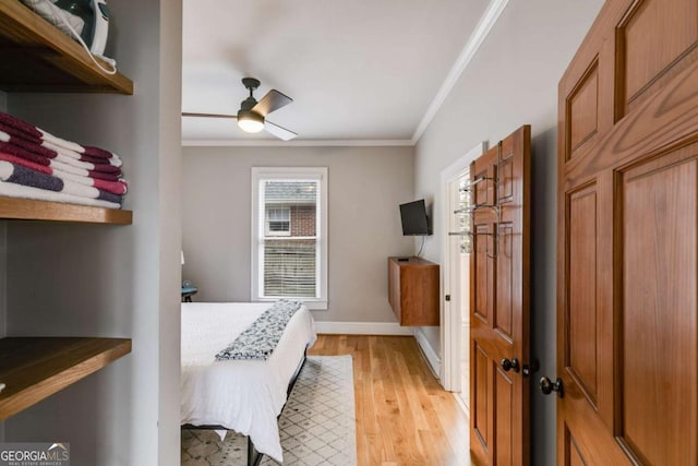 bedroom featuring ornamental molding, light hardwood / wood-style floors, and ceiling fan