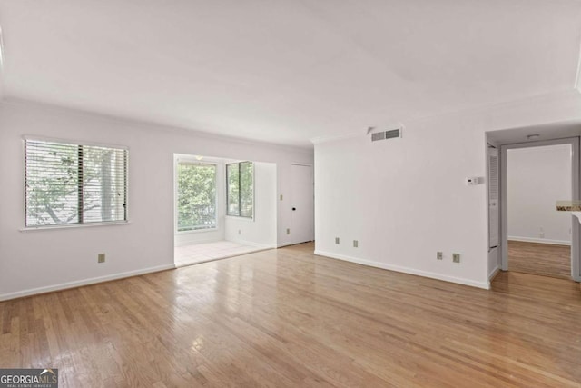 empty room featuring crown molding and light hardwood / wood-style flooring