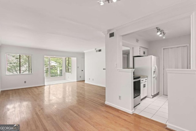 kitchen featuring white refrigerator with ice dispenser, stainless steel range with electric cooktop, and light wood-type flooring