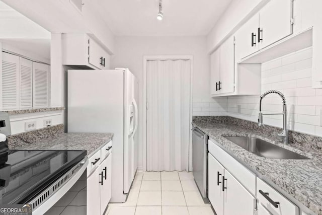 kitchen with sink, electric range oven, tasteful backsplash, white cabinets, and stainless steel dishwasher