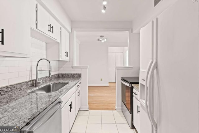 kitchen featuring stainless steel appliances, white cabinetry, sink, and backsplash