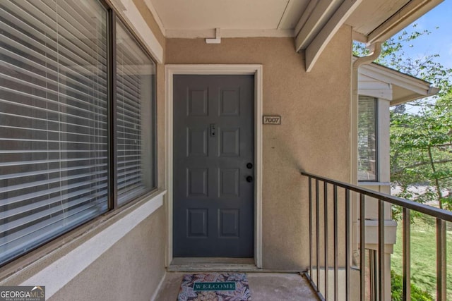 view of exterior entry featuring a balcony