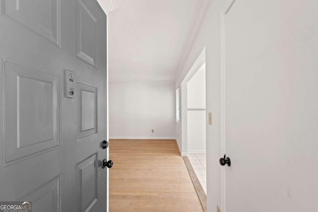 hallway with crown molding and light hardwood / wood-style flooring