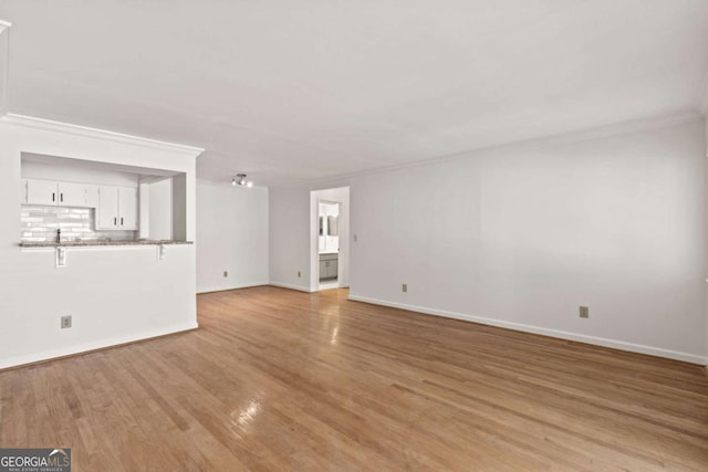 unfurnished living room featuring crown molding and light hardwood / wood-style floors