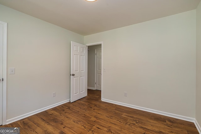 empty room with dark hardwood / wood-style flooring