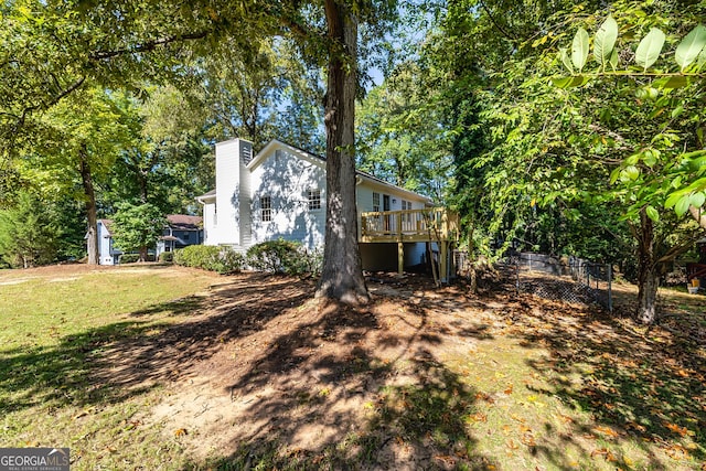 view of side of home featuring a wooden deck and a yard