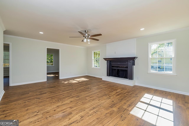 unfurnished living room with crown molding, a brick fireplace, hardwood / wood-style floors, and ceiling fan