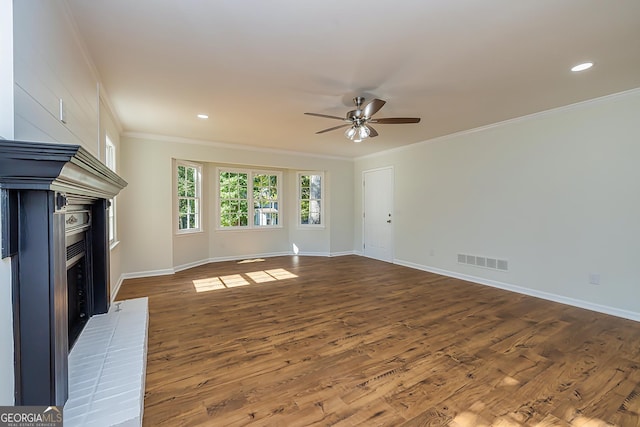 unfurnished living room with ceiling fan, a fireplace, ornamental molding, and dark hardwood / wood-style flooring