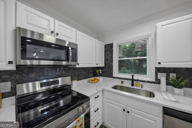 kitchen with sink, tasteful backsplash, appliances with stainless steel finishes, light stone countertops, and white cabinets