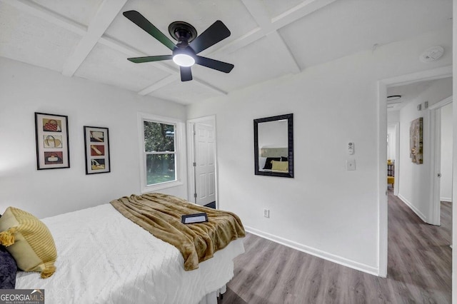 bedroom featuring coffered ceiling, hardwood / wood-style floors, beamed ceiling, and ceiling fan