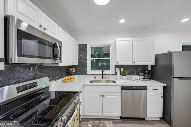 kitchen with white cabinetry, sink, light stone counters, and appliances with stainless steel finishes