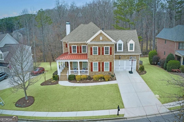 view of front of home with a garage, a front yard, and covered porch