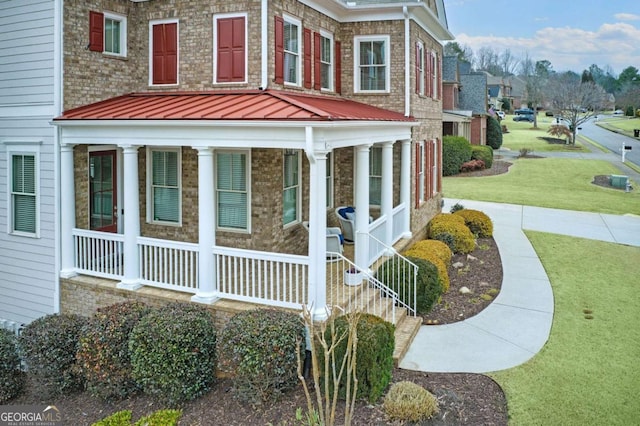 view of side of property with a porch and a yard