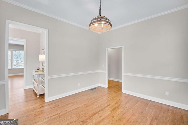 empty room with ornamental molding and light hardwood / wood-style flooring