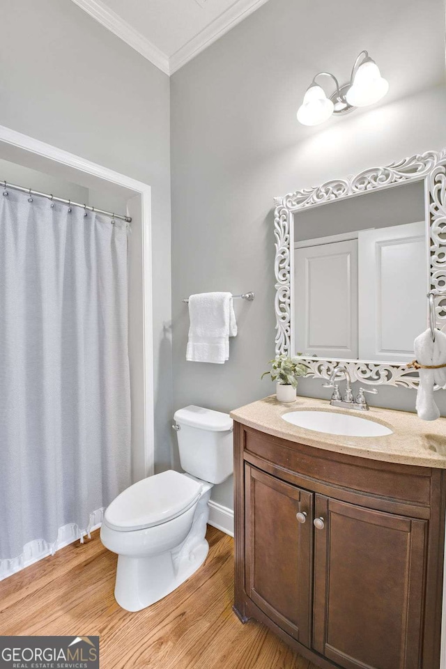 bathroom featuring vanity, crown molding, toilet, and hardwood / wood-style flooring