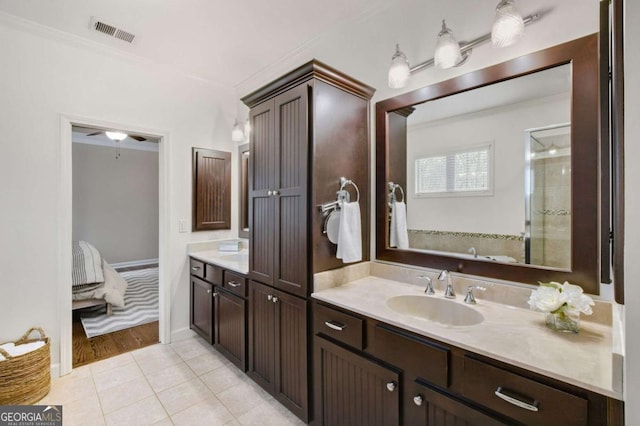 bathroom with a shower with door, crown molding, tile patterned floors, and vanity