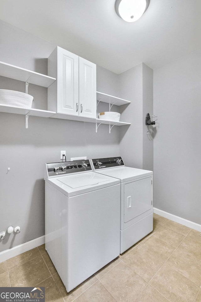 laundry area featuring separate washer and dryer and cabinets