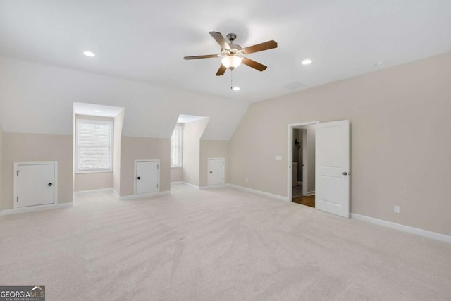 additional living space with lofted ceiling, light colored carpet, and ceiling fan