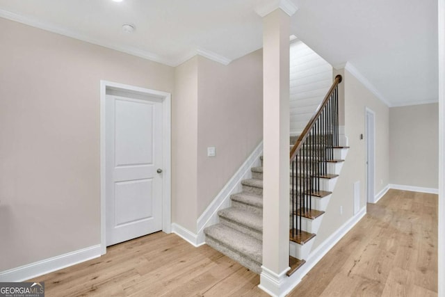 stairs with crown molding and hardwood / wood-style floors