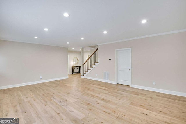 unfurnished living room featuring crown molding and light hardwood / wood-style floors