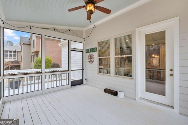 unfurnished sunroom featuring ceiling fan