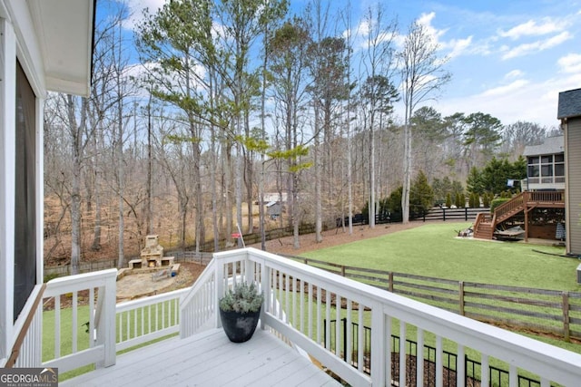 wooden terrace featuring a yard and a fireplace