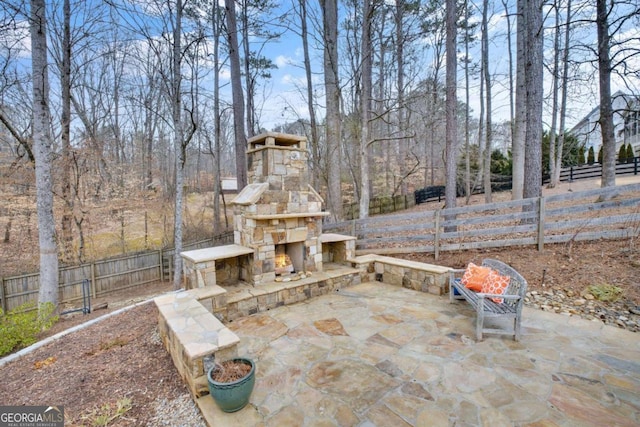 view of patio featuring an outdoor stone fireplace