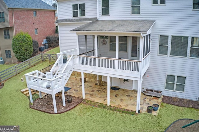 rear view of house with a patio, central air condition unit, and a lawn