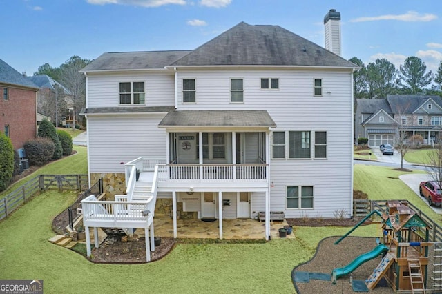 back of house with a patio, a playground, a sunroom, and a lawn