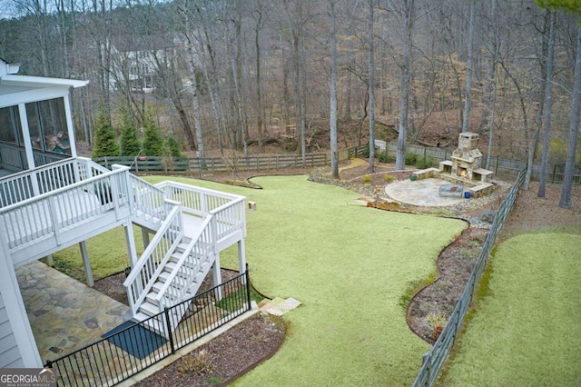 view of yard featuring a deck, a fireplace, and a patio area