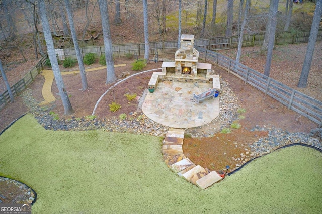 view of yard featuring a patio and an outdoor stone fireplace