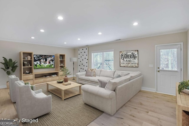 living room with crown molding and light hardwood / wood-style floors