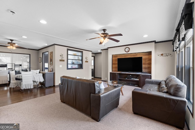 carpeted living room featuring crown molding and ceiling fan