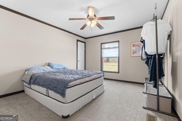 carpeted bedroom with ornamental molding and ceiling fan