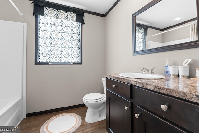 full bathroom with ornamental molding, toilet, hardwood / wood-style floors, and vanity