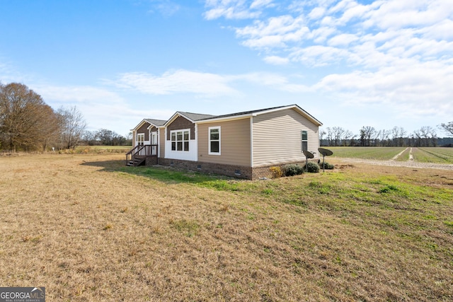 view of home's exterior featuring a rural view and a yard