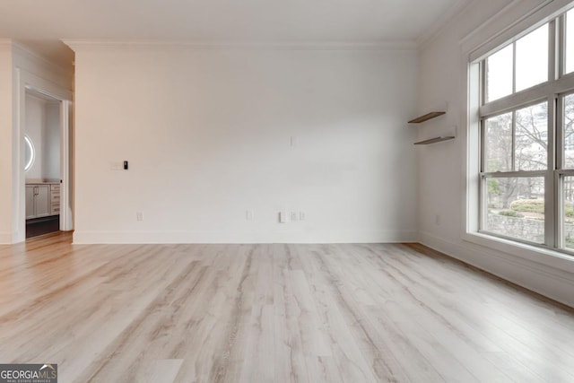 spare room featuring crown molding and light wood-type flooring