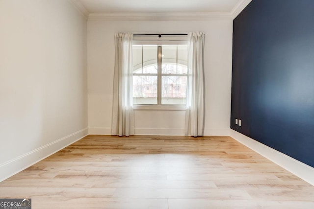 empty room featuring ornamental molding and light hardwood / wood-style floors