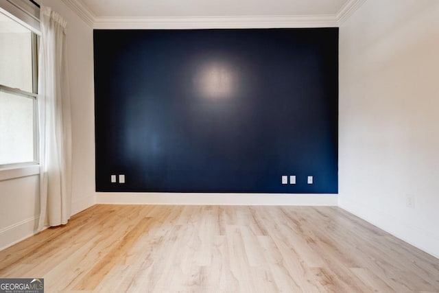 spare room featuring crown molding and light hardwood / wood-style flooring