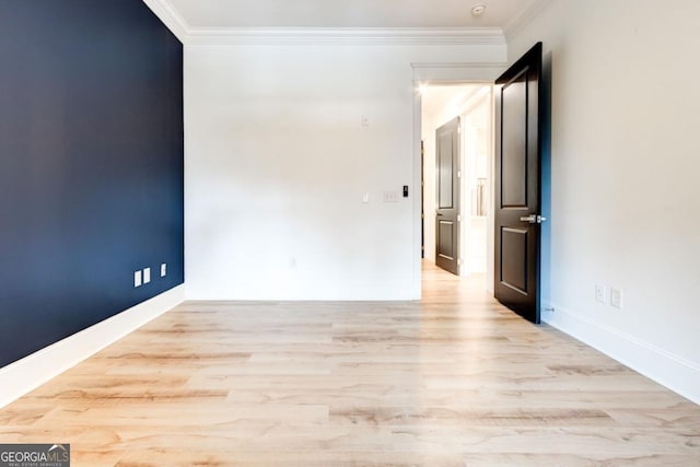 unfurnished room featuring ornamental molding and light wood-type flooring