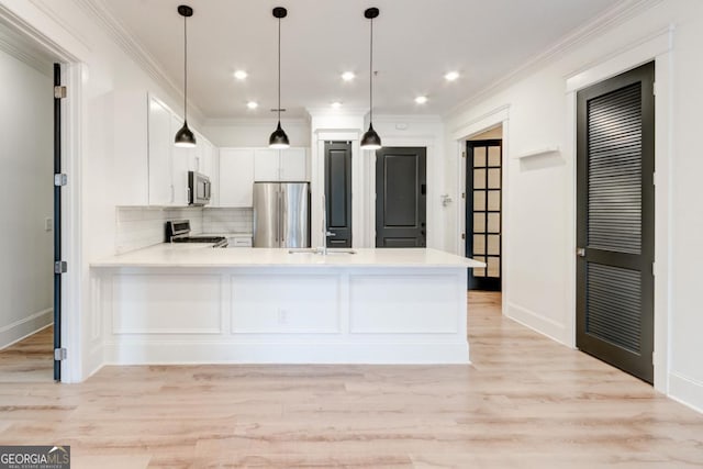 kitchen featuring decorative light fixtures, white cabinets, kitchen peninsula, stainless steel appliances, and light hardwood / wood-style flooring