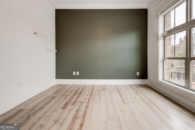 unfurnished room featuring ornamental molding, a healthy amount of sunlight, and light wood-type flooring