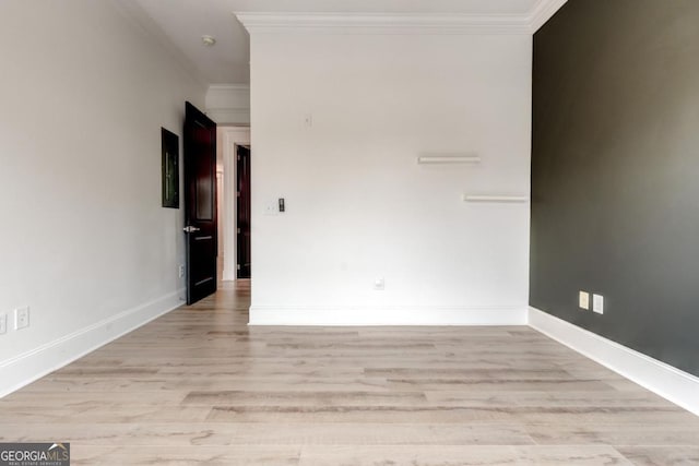 spare room with ornamental molding and light hardwood / wood-style floors