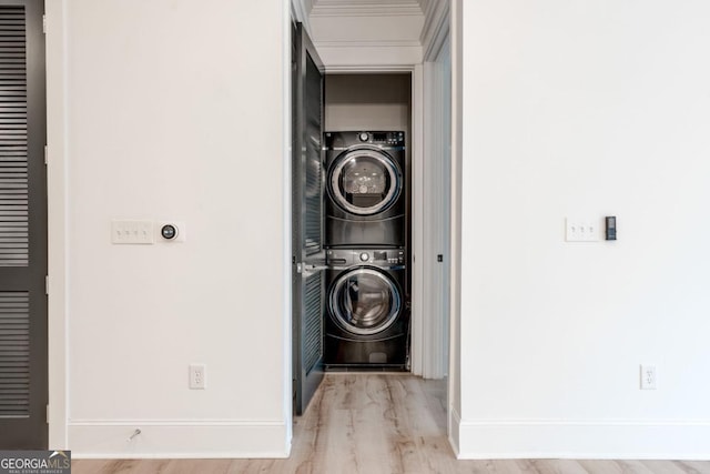 washroom featuring stacked washer and dryer and light wood-type flooring