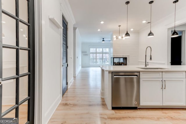 kitchen with ornamental molding, dishwasher, sink, and white cabinets