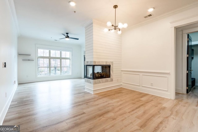 unfurnished living room with ceiling fan with notable chandelier, ornamental molding, light hardwood / wood-style floors, and a multi sided fireplace