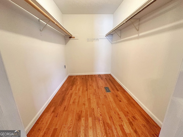 walk in closet with light wood-type flooring