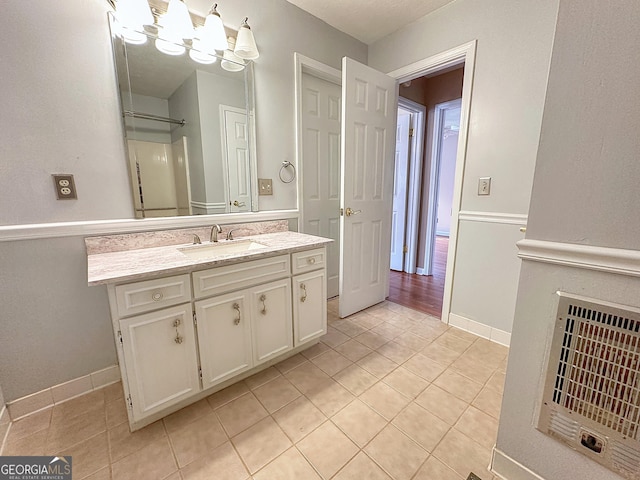 bathroom featuring tile patterned flooring, vanity, and heating unit