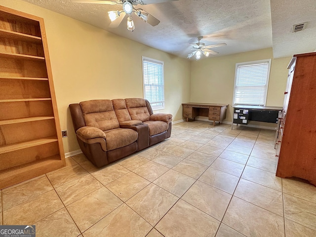 unfurnished living room featuring built in shelves, plenty of natural light, and a textured ceiling